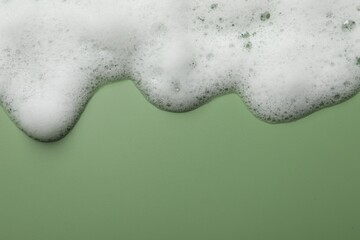 Fluffy soap foam on green background, top view. Space for text - obrazy, fototapety, plakaty