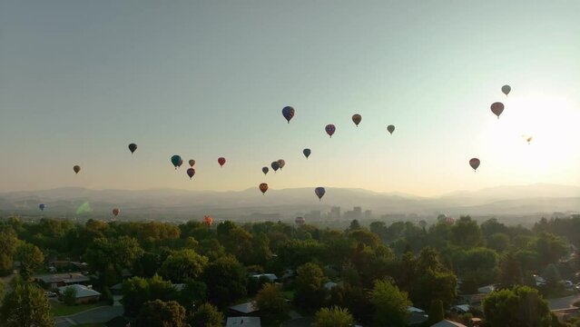 Hot air balloons floating above an American town, racing to their destination.