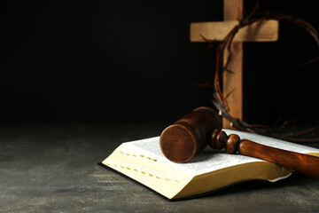 Judge gavel, bible, wooden cross and crown of thorns on grey table. Space for text