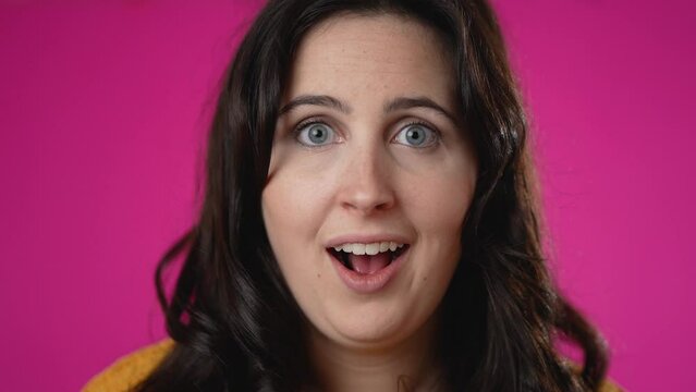 Closeup slow motion portrait of excited young woman 20s anticipate great success, winner, isolated on pink background.