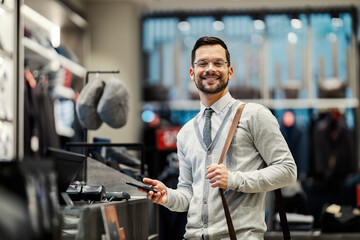 Portrait of a happy elegant buyer using cashless technology for purchase.