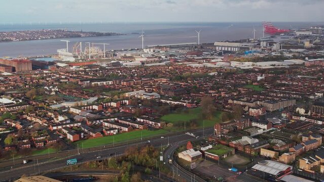 Aerial panning shot of Everton Football Club's new stadium with mouth of River Mersey and Liverpool docks