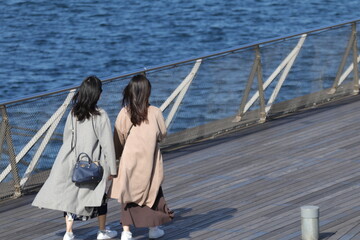 横浜港の大さん橋を歩く二人の若い女性