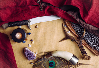 Fantasy live action role play game concept. Background decorated with various character objects tools: Dagger, chain mail, cape, clothing, drinking horn. Vintage style, copy space in center.