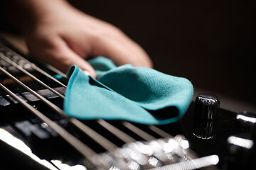 close-up of a cleaning cloth being used on an electric bass guitar