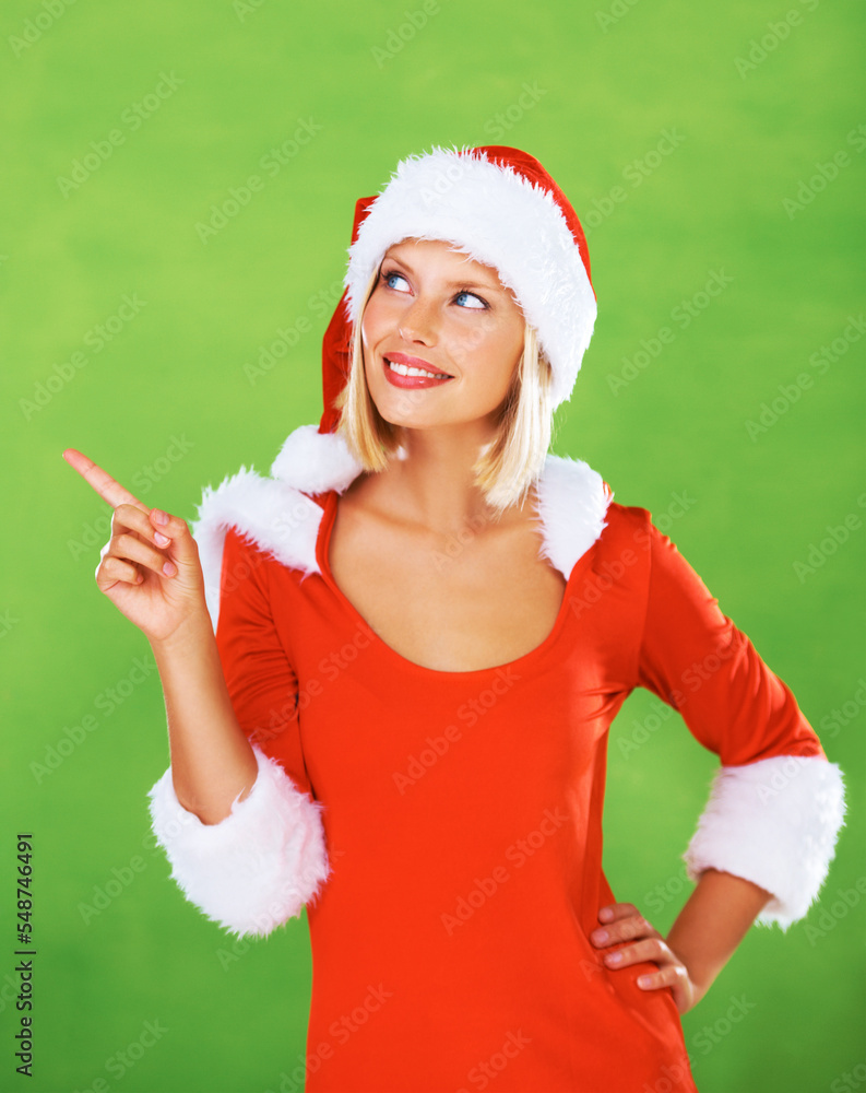 Wall mural Christmas outfit, young woman and pointing with smile, happy and joyful for marketing, advertising and with studio background. Xmas, female or girl thinking, happiness or festive with mockup or green