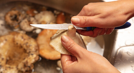 Cleaning mushrooms with a knife and water.