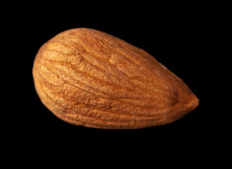 One almond nut isolated on black background.