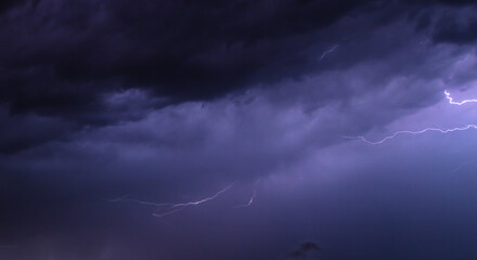 Fototapeta na wymiar Lightning in the sky at night as an background.