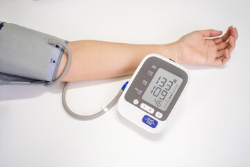 Woman measures blood pressure, with copy space on white background