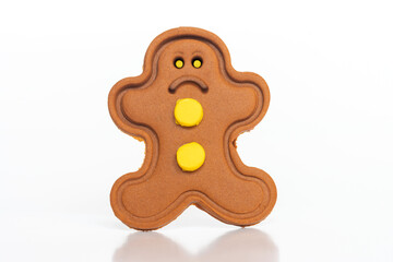 Gingerbread man figure with unhappy mimic on a white background