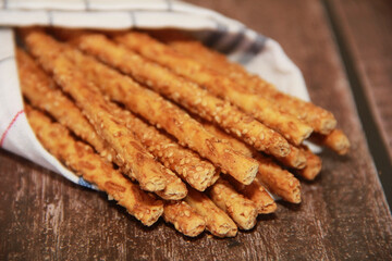 dry sesame bread sticks with small seeds for dietary nutrition, on a wooden background