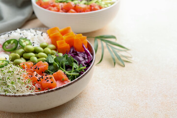 Delicious poke bowls with vegetables, fish and edamame beans on light table, closeup. Space for text