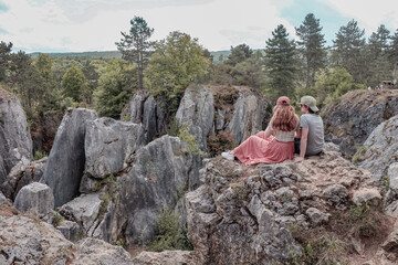 Couple sitting on rock enjoying the views of the nature of Fondry des Chiens in Vironinval Belgium.