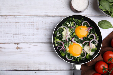 Flat lay composition with tasty Shakshouka and ingredients on white wooden table. Space for text