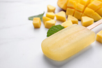 Tasty mango ice pop on white table, space for text. Fruit popsicle