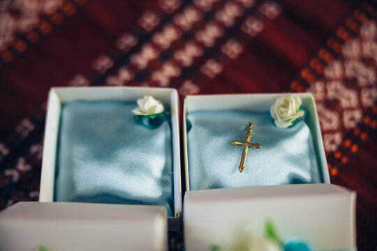 A little golden cross in a jewelry box prepared for a baby's christening baptism ceremony. High quality photo