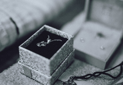 A little golden cross in a jewelry box prepared for a baby's christening baptism ceremony. Black and white photo. High quality photo