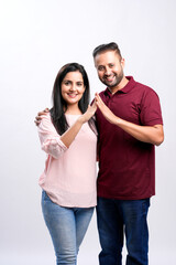 Indian couple making home symbol with hand on white background.