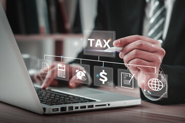 Businessman pointing pen to TAX word on computer screen, concept, personal income tax, tax payment,...
