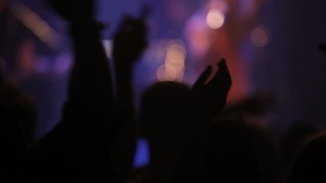 Audience hands, wave and silhouette, concert and music, singing and dancing at music festival and live entertainment with bokeh. Night life at club, artist or singer on stage with dance party and fun