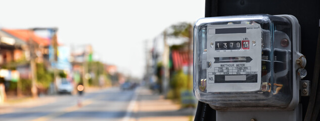 Watthour meter of electricity hung on the cement pole beside the road to monitor and measure power usage each houses in Asian countres.