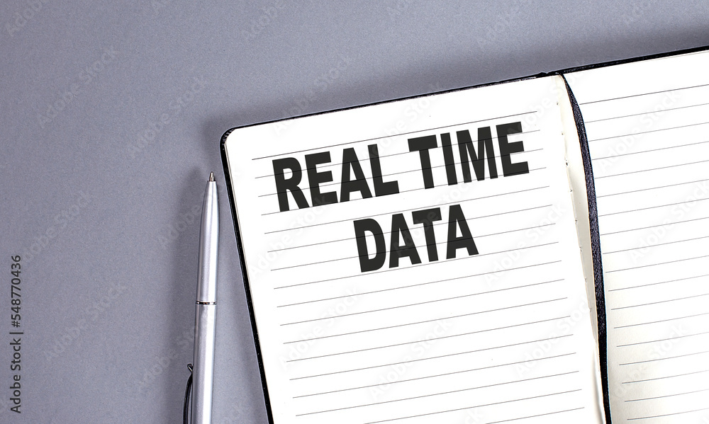 Aufkleber real time data word on the notebook with pen