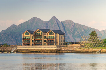 Golden hour and reflections of rorbuer on the water in Svolvaer,  Austvågøya, Lofoten Islands, Norway