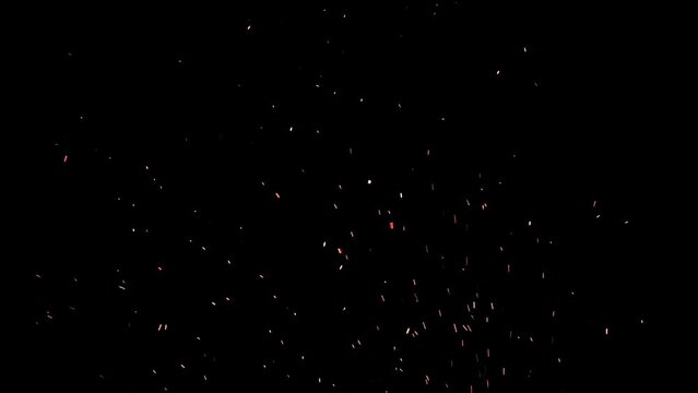 Slow motion of real glowing ember sparks ideal to use as an overlay. The ash particles are flowing gently in the night sky. 