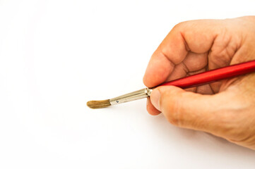 male hand holding a paint brush, isolated