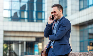 Businessman making a phone call in front of the corporation. Business, lifestyle concept