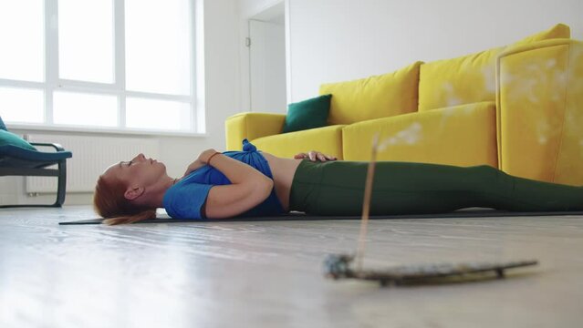 Adult woman lies on the floor and doing breathing practices