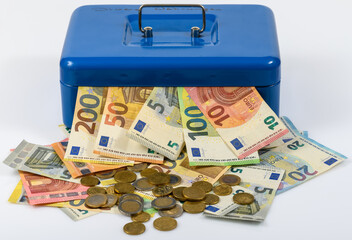 euro bills and coins lying on table and sticking out of blue cash box