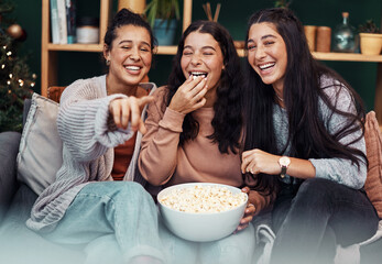 Christmas isnt complete without a fun movie marathon. Shot of young sisters having popcorn and...