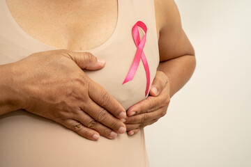 Breast cancer, pink ribbon at Asian senior lady for supporting awareness, symbol of World Breast Cancer Day.