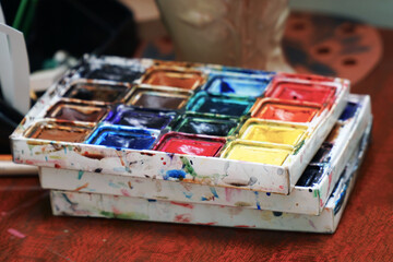 Watercolor paints on the table. Selective focus