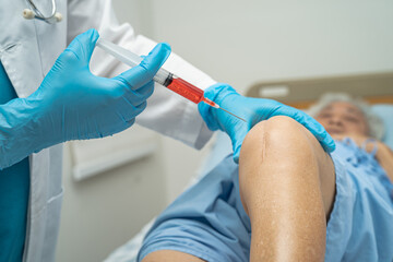 Asian doctor inject Hyaluronic acid platelet rich plasma into the knee of senior woman to walk without pain.
