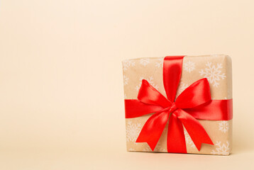 Gift box with red ribbon bow on color background
