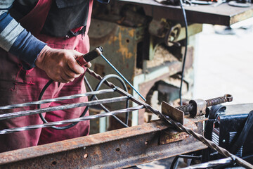 a man welds a metal with a welding machine, profession of welder, weld metal, man works with metal