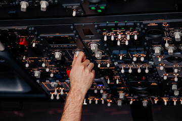 Pilot hand is controlling plane toggle switches to fly take off and landing