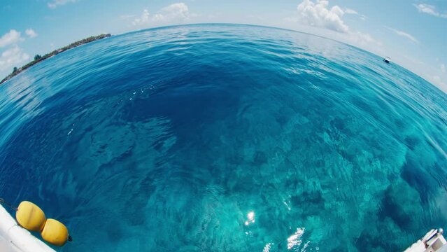 Calm sea surface during the sunny windless day in the Maldives as seen from the boat