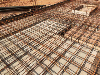 Fototapeta premium MELAKA, MALAYSIA -JULY 2, 2022: Steel reinforcement bars are arranged according to the structural engineer's design. The steels are tied together using a small steel wire.