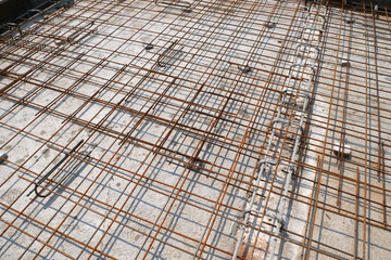 MELAKA, MALAYSIA -JULY 2, 2022: Steel reinforcement bars are arranged according to the structural engineer's design. The steels are tied together using a small steel wire.