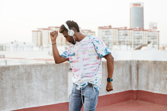 Black man dancing while listening to music on headphones