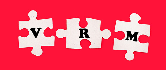 Three white jigsaw puzzles with the text VRM Vendor Relationship Management on a bright red background.