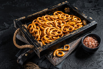 Snack box with salty pretzels crackers. Black background. Top view