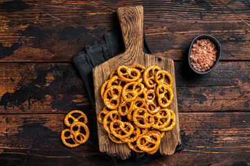 Snack Salted crispy Pretzel on wooden board. Wooden background. Top view