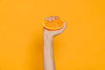 Female hand squeezing orange isolated