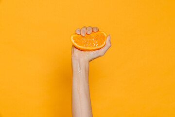 Female hand squeezing orange isolated