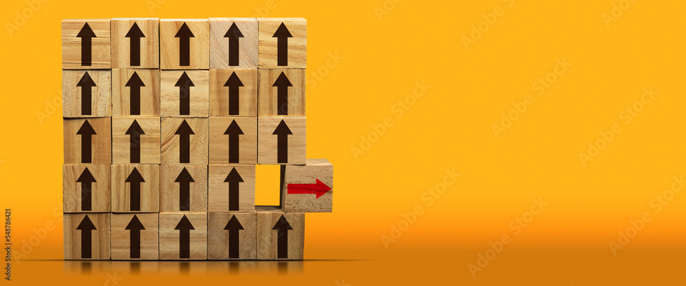 Poster concept of standing out from the crowd. group of wooden blocks with brown arrows and a wooden cube w